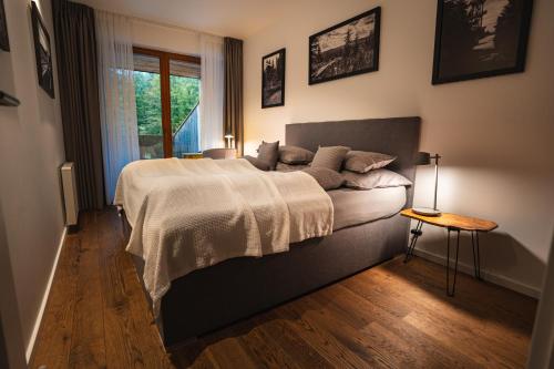 Un dormitorio con una cama grande y una ventana en Apartman Milíř - ADULTS ONLY, en Bedřichov