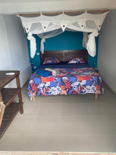 a bedroom with a bed with a canopy at Vue imprenable sur la mer des Caraïbes in Les Anses-dʼArlets