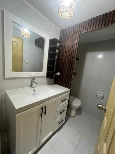 a bathroom with a sink and a toilet and a mirror at The Lotus Suite2 Iloilo in Iloilo City