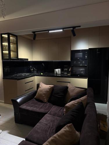 un sofá en una sala de estar con cocina en Magic Garden, en Tiflis