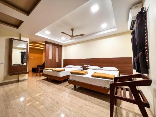 a bedroom with two beds and a mirror at Shri Amman Residency in Dhārāpuram