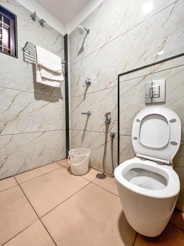 a bathroom with a toilet and a shower at Shri Amman Residency in Dhārāpuram