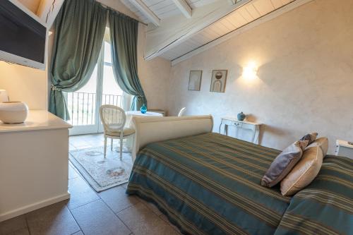ein Schlafzimmer mit Bett, Schreibtisch und Fenster in der Unterkunft Locanda San Giorgio in Neviglie