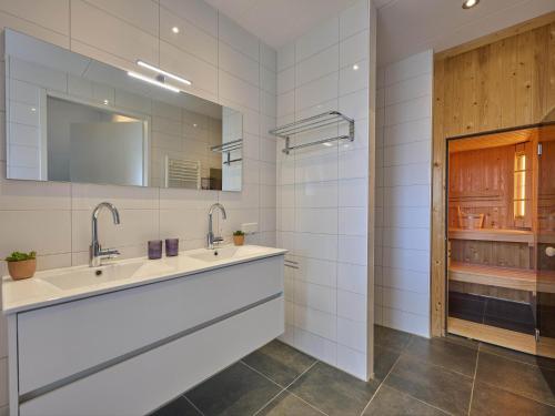 a bathroom with two sinks and a mirror at SeaLuxe Suite 27i in Colijnsplaat