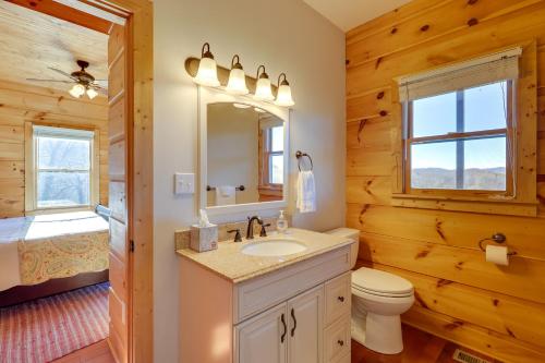 a bathroom with a toilet sink and a mirror at Decks and Panoramic Views Rustic Sparta Cabin in Sparta