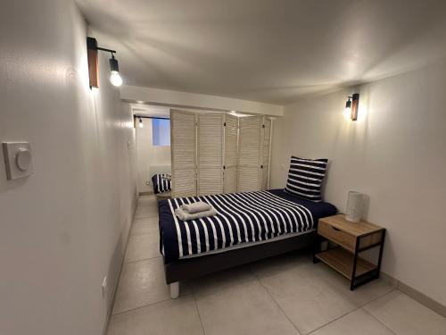 a small bedroom with a bed and a table at Chez Camille & Emma - Loft Climatisé in Rochefort