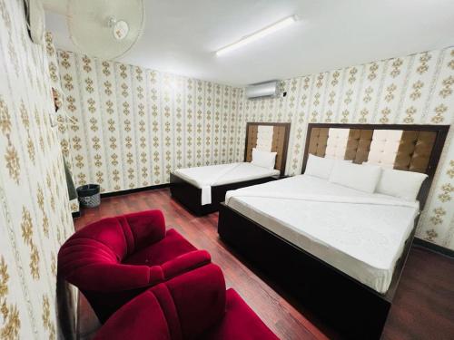 イスラマバードにあるFrank-inn Guest House Islamabadの大きなベッドと椅子のある寝室