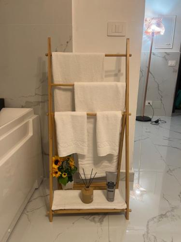 a towel rack with towels and flowers in a bathroom at Nuvola Luxury suite in Turin