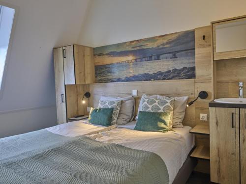 a bedroom with a large bed with a painting on the wall at Sauna Zee 27H in Colijnsplaat