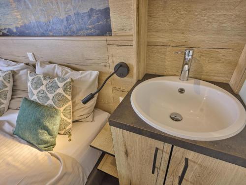 a bathroom with a sink and a bed at Sauna Zee 27H in Colijnsplaat