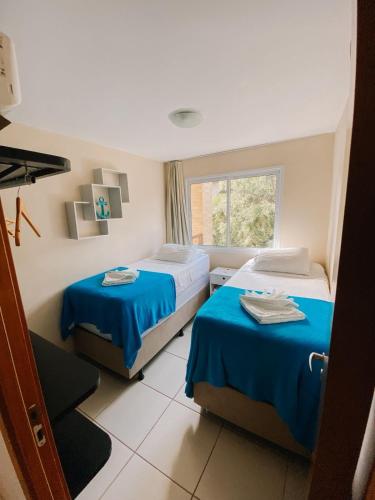 ピパにあるApartamento mobiliado no Pipa Paradiseのベッドが2つと窓があるホテルの部屋