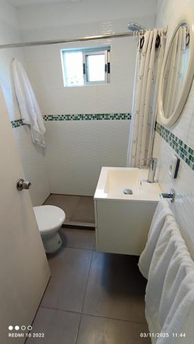 ein weißes Badezimmer mit Waschbecken und Toilette in der Unterkunft Lolamora in Balneario Buenos Aires