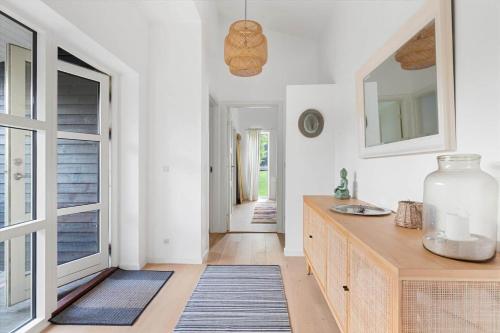 een keuken met een wastafel en een aanrecht met een spiegel bij 823-Tisvildeleje-Vibevaenget-13-A in Tisvilde