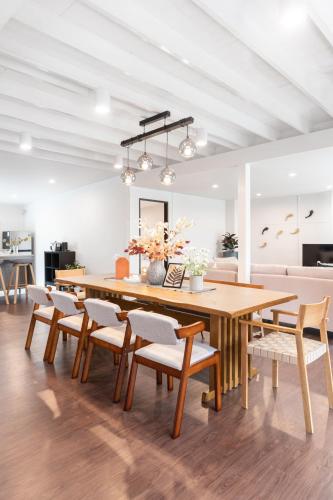 a dining room with a large wooden table and chairs at The Mellow at Ekkamai in Bangkok