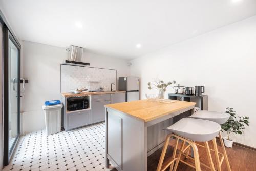 a kitchen with a counter and stools in it at The Mellow at Ekkamai in Bangkok