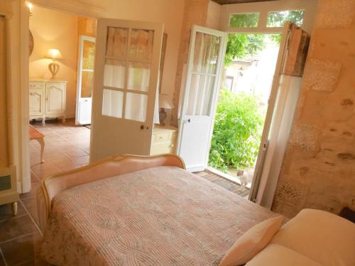 a bedroom with a bed and an open door at L'Arbre D'Ange in Montmorillon