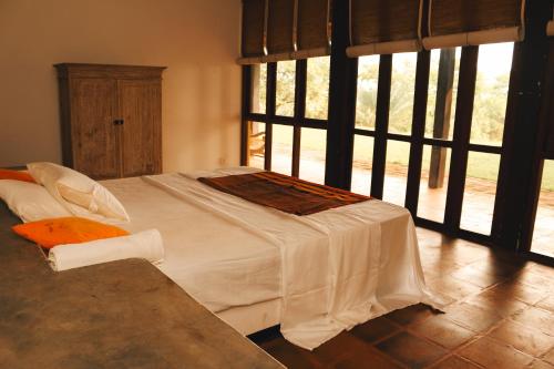 a white bed in a room with a window at Panai Adi Boutique Villa in Kuravankudil