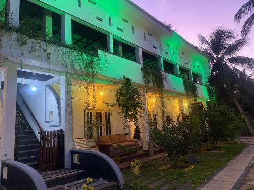 a building with green lights on the side of it at Jasmine Chill Cafe & Guest House in Chilaw