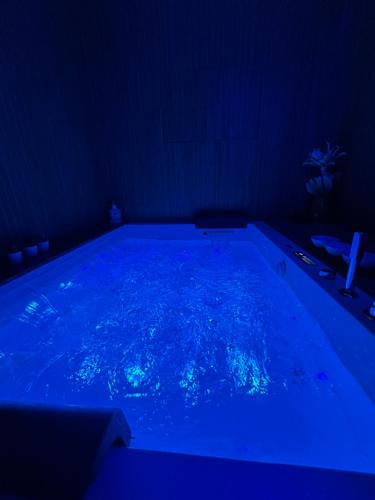 ETNA HOUSE LUXURY con giardino e vasca idromassaggio في لينغواغلوسا: حمام سباحة مع إضاءة زرقاء في غرفة مظلمة