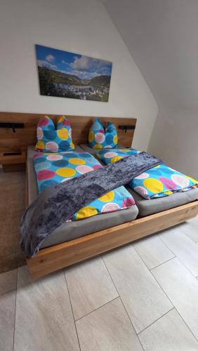 Moselkieker في برودنباخ: غرفة نوم مع سرير مع أوراق ووسائد ملونة