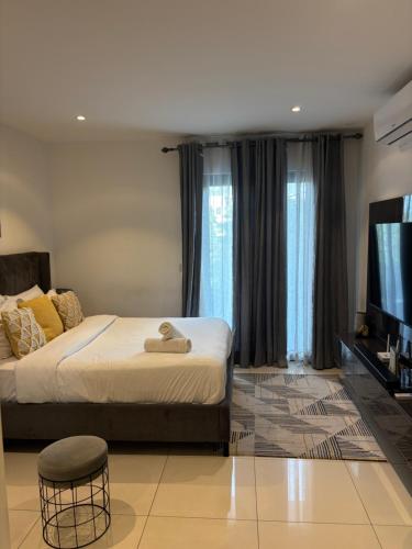 a bedroom with a bed and a flat screen tv at Bloom Styled Studio at The Lennox in Accra