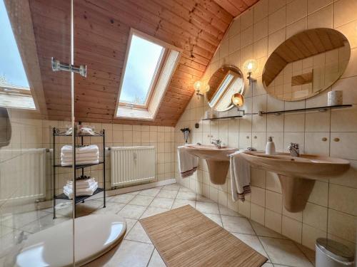 a bathroom with two sinks and two mirrors at Weiherblasch II in Dietersdorf