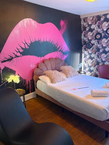 a bedroom with a bed with a pink lips headboard at La Parisienne Coquine Love and Plaisir - Love Room in Troyes