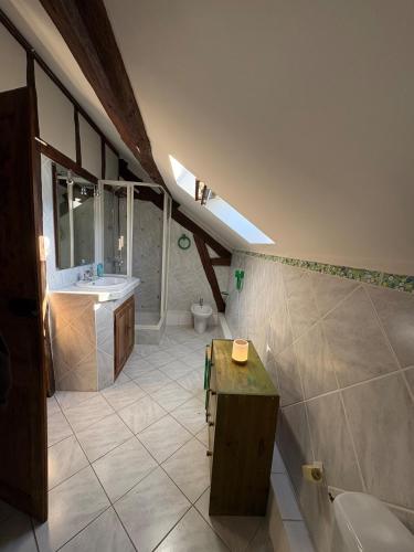 ein großes Bad mit einem Waschbecken und einem WC in der Unterkunft La ferme de Jose in Guainville