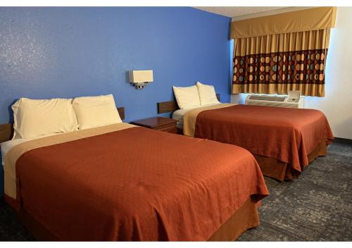 a hotel room with two beds and a blue wall at Conn Brown Harbour Inn Aransas Pass Corpus Christi in Aransas Pass