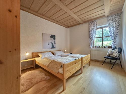 a bedroom with a large wooden bed in a room at Weiherblasch I in Dietersdorf