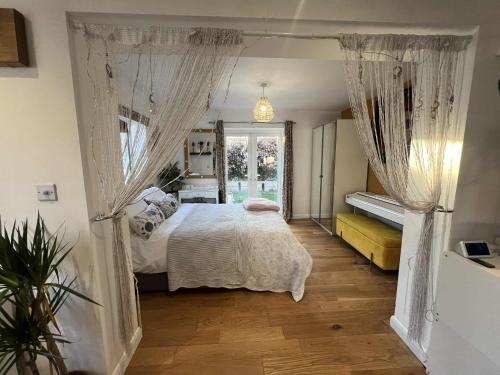 a bedroom with a bed with curtains and a window at Ty Cariad in Saundersfoot