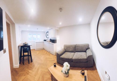 ein Wohnzimmer mit Sofa und Tisch in der Unterkunft Little Dunton Lodges 2 in Brentwood