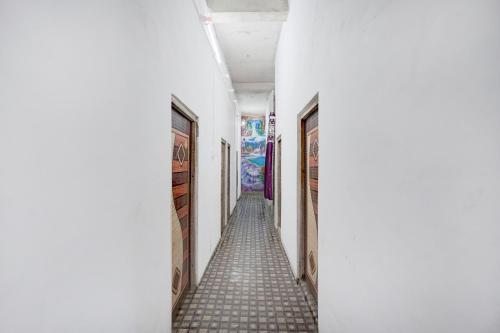a long hallway with white walls and tile floors at SPOT ON HM HOTEL in Mundarwa