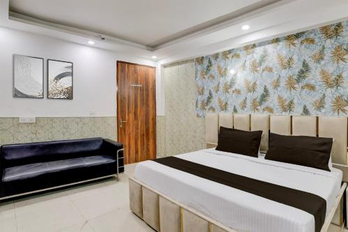 a bedroom with a large bed and a couch at Hotel O Akki Residency in Indirapuram