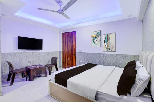 a bedroom with a bed and a table and a tv at Hotel O Akki Residency in Indirapuram