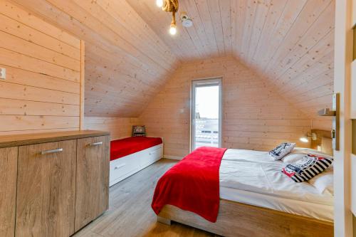 a bedroom with a bed in a wooden house at Kotwisko in Sarbinowo