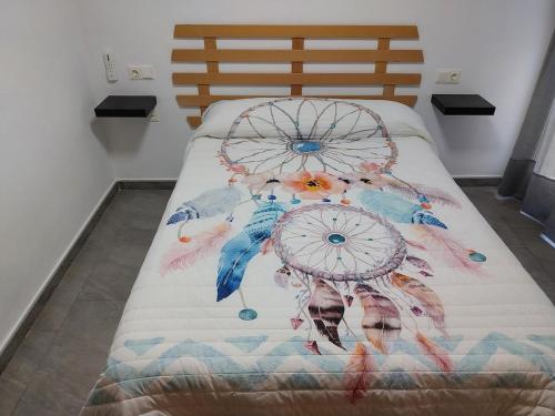 a bed with a comforter with birds on it at Ca L'Esparter in Bocairent