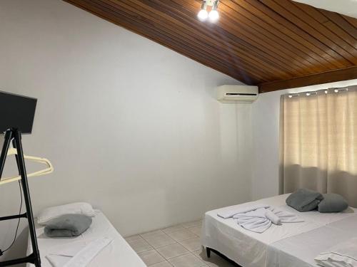 a room with a bed and a television in it at Pousada Sagrada Devoção in Aparecida
