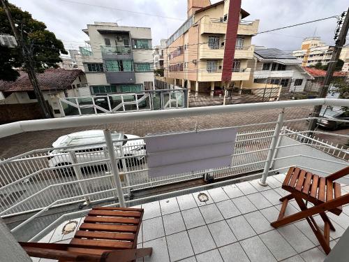 a balcony with two chairs and a car on a street at com churrasqueira em Canasvieiras in Florianópolis