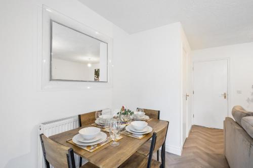 a dining room with a table and a mirror at Cozy Two Bedroom House with Driveway Parking & Garden in Chatham