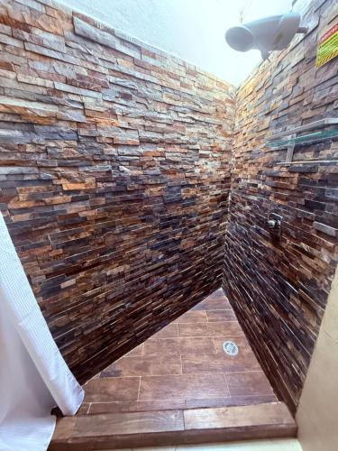 a bathroom with a stone wall at Sabalo's Hausen in Mazatlán