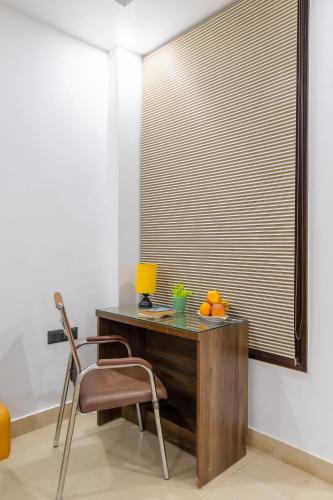 ノイダにあるHotel Aura Grand sector 63A Noida I Couple Friendlyのデスク(ブラインド付きの窓際の椅子付)