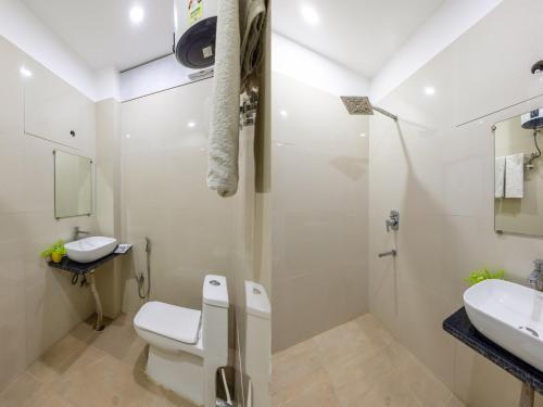 a white bathroom with a toilet and a sink at Hotel Aura Grand sector 63A Noida I Couple Friendly in Noida