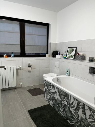 a bathroom with a bath tub and a window at Gästezimmer 21qm im Casa Kirchweg in Gladbach