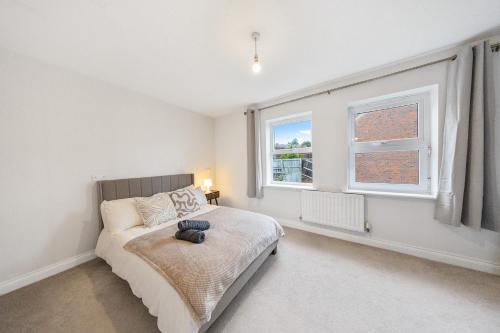 a bedroom with a bed and a window at Cozy Two Bedroom House with Driveway Parking & Garden in Chatham