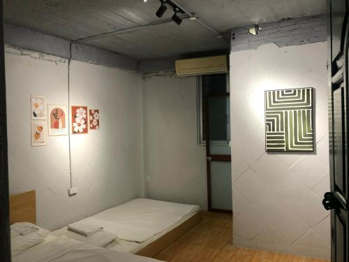 a room with a bed and a wall with art at Ubuntu Central Stay 57 Hang Be in Hanoi