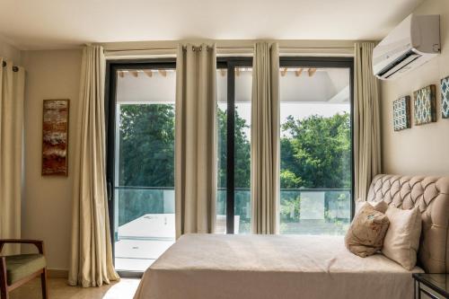 a bedroom with a bed and a large window at Ka' Romana Residences in El Soco