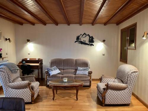 a living room with two couches and a table at Gîte 6 personnes Chez Gaby in Montgreleix