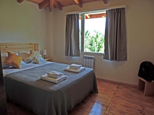a bedroom with a bed with two towels on it at Río Epuyén Aparts in El Hoyo
