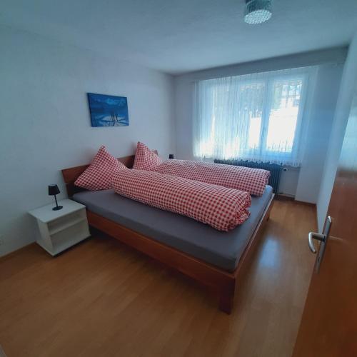 ein Schlafzimmer mit einem Bett mit roten und weißen Kissen in der Unterkunft Bunderbach in Adelboden